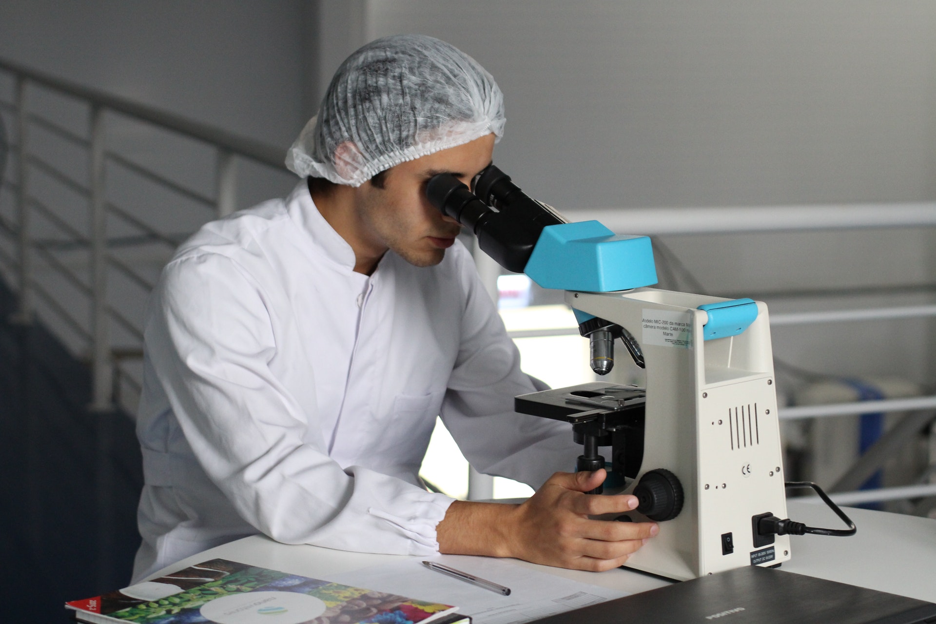 technician looking at sample under microscope